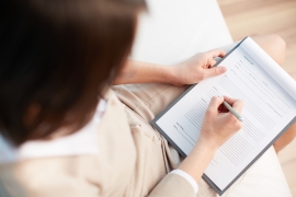 female-counselor-writing-down-some-information-about-her-patient-SBI-300734233