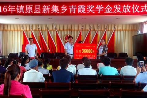 2 2016年镇原县新集乡青霞奖学金发放仪式:基金工作人员将捐赠牌递交给新集乡书记和学生代表